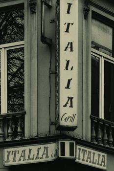 Sepia-toned image of an Italian restaurant facade with classic design and signage.
