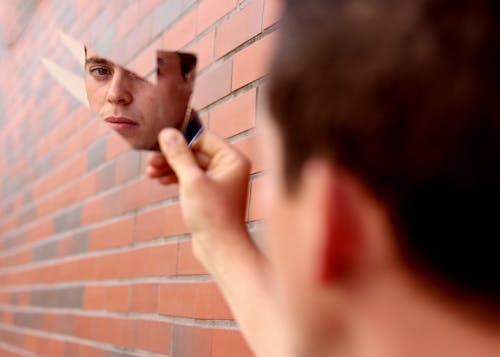 Free Man Mirroring in Broken Glass Stock Photo