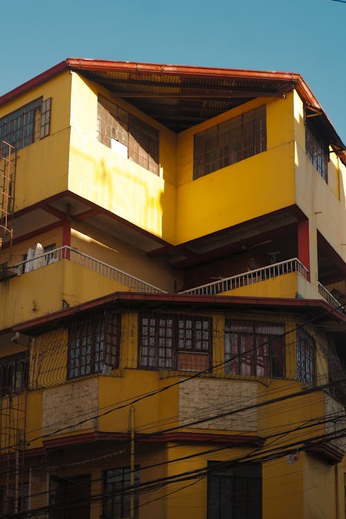 A yellow building with a balcony and stairs