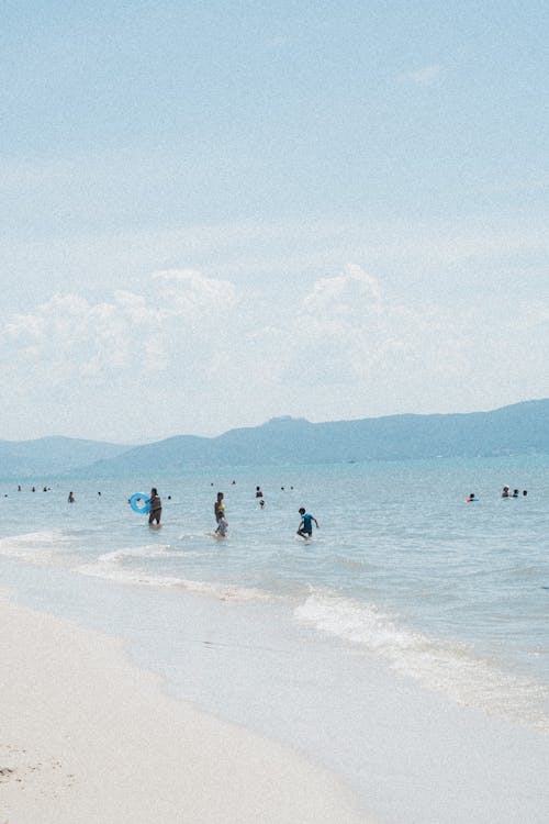 People are walking on the beach with the ocean in the background