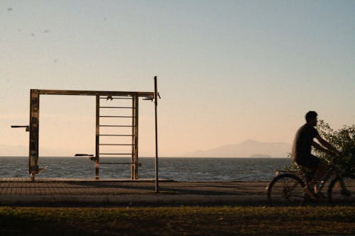 A man riding a bike near the water