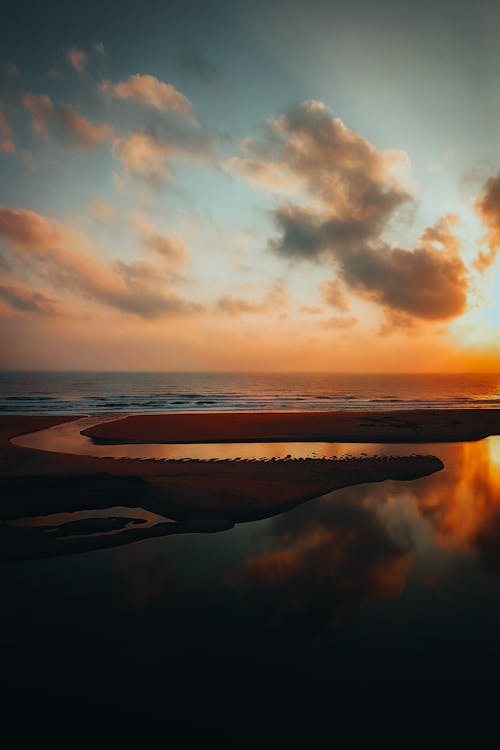A sunset over the ocean with a reflection in the water