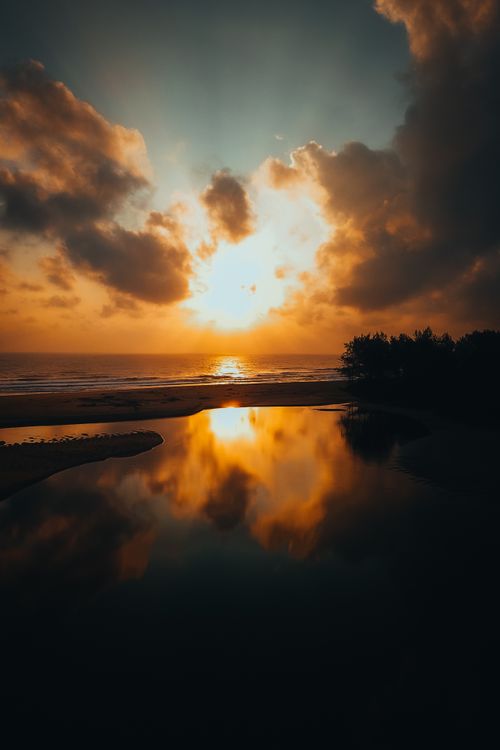 Free Breathtaking sunset with vibrant colors reflecting in water at Kijal Beach, Malaysia. Stock Photo