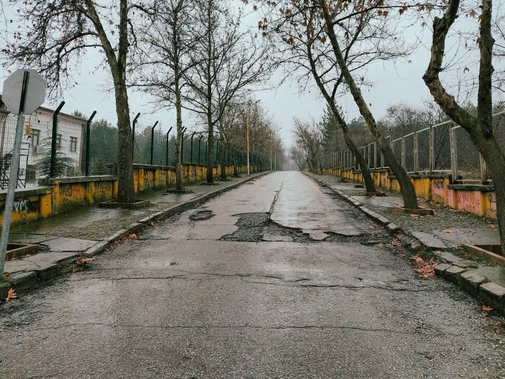 طريق أسفلتي متدهور تملؤه الشقوق والحفر طريق أسفلتي متدهور تملؤه الشقوق والحفر