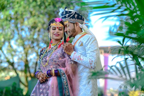 A couple in traditional attire pose for a photo