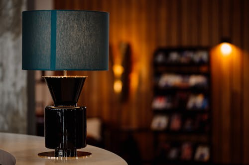 A table lamp with a blue shade on top of a table