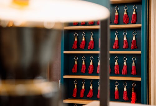 A shelf with red and blue tassels hanging from it