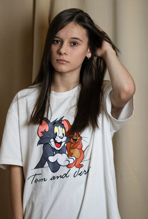 A girl wearing a t - shirt with a cartoon cat on it