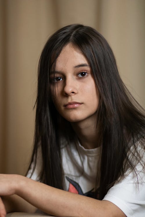 A young woman with long hair sitting down