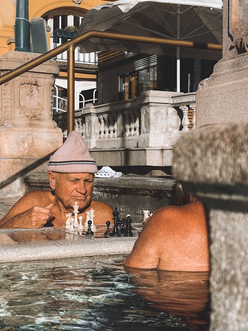 Two men playing chess in a hot tub
