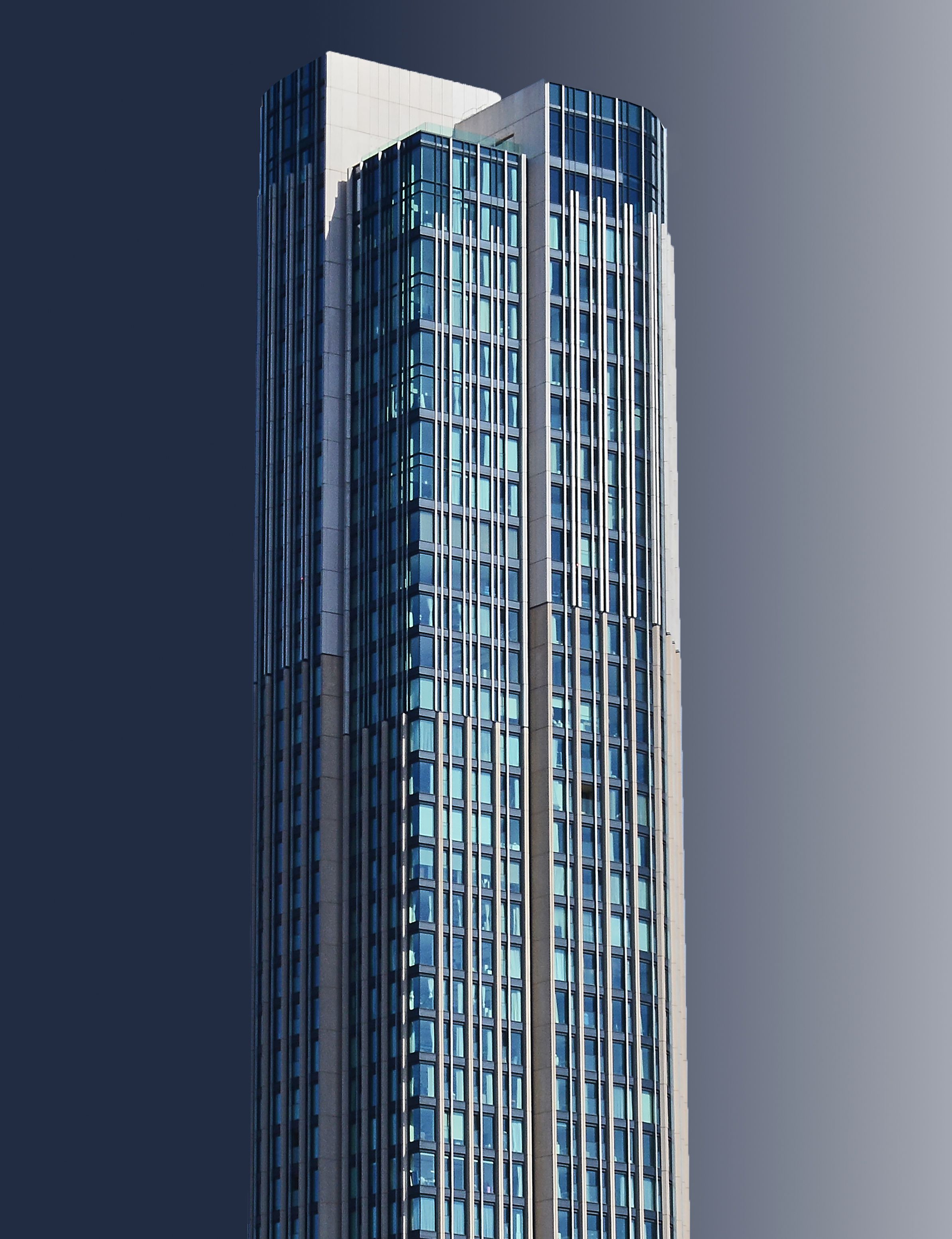 Tall glass skyscraper with modern architecture against a clear sky.