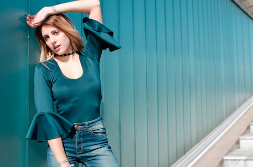 Free Woman Leaning Against Blue Wall Stock Photo