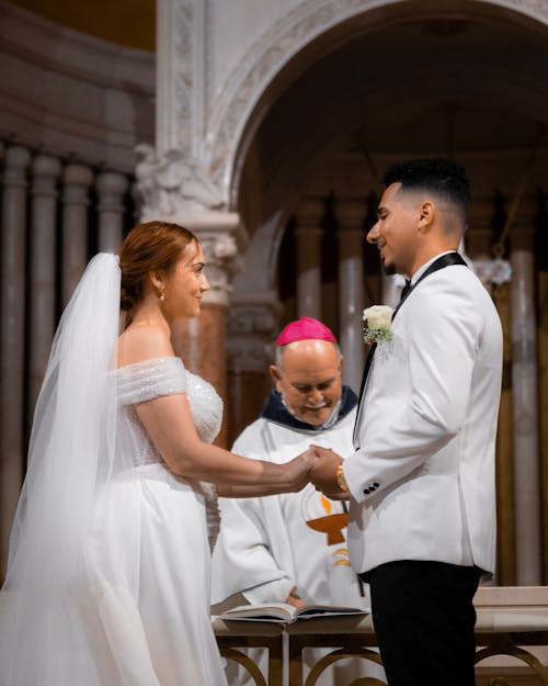 A bride and groom are standing at the altar