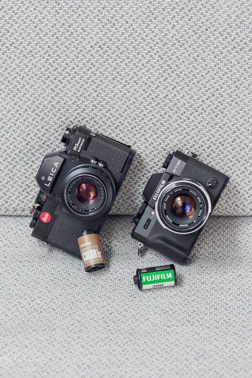 Two cameras with batteries and a battery charger