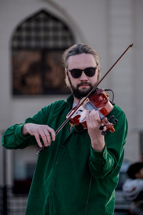 A man in sunglasses playing the violin