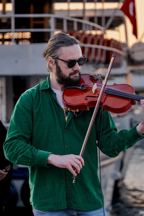 A man with beard and sunglasses playing violin