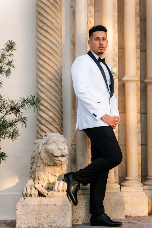 A man in a white tuxedo posing for a photo