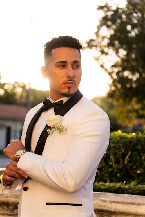 Groom in White Tuxedo Adjusting His Cuff