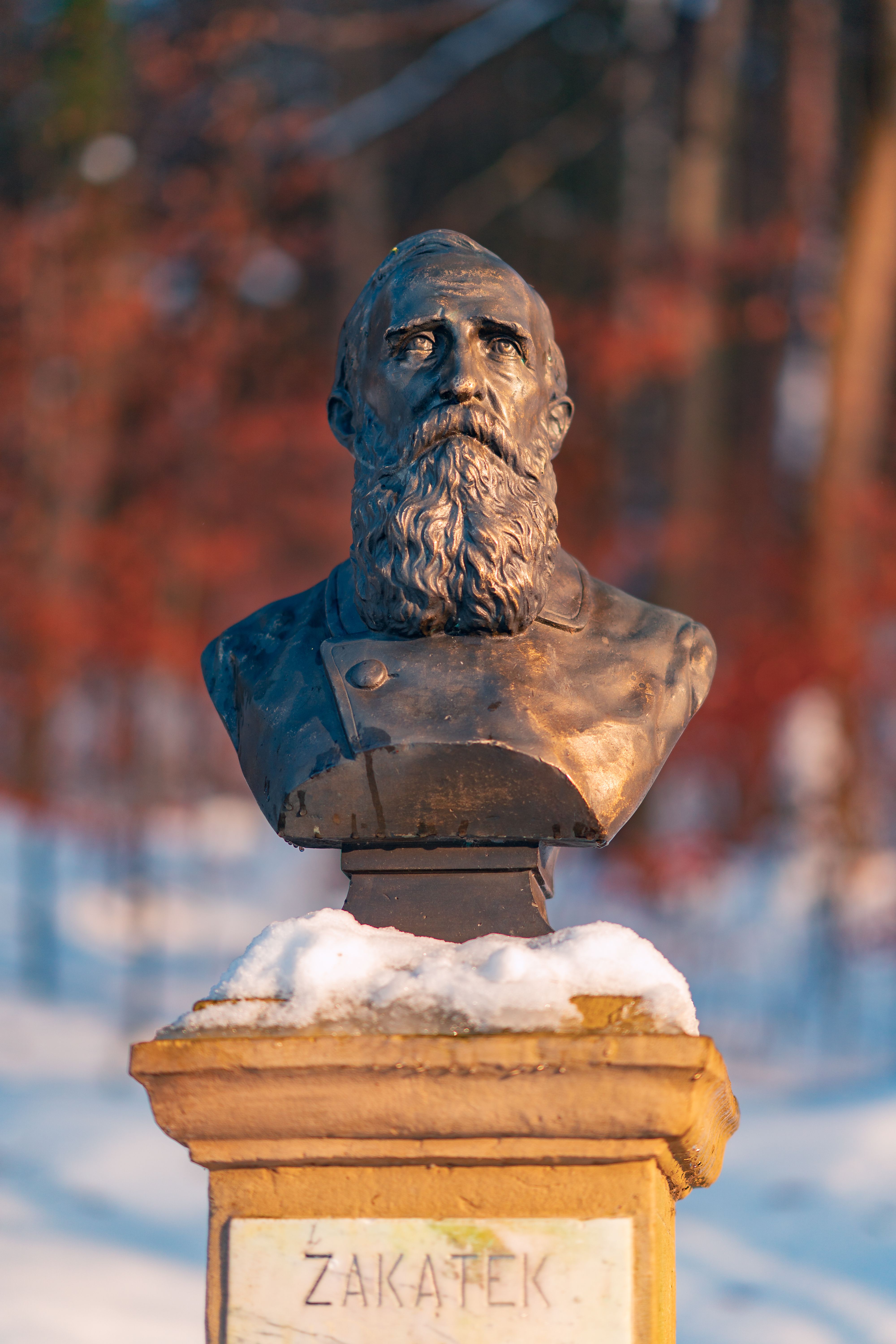 Bronze bust of Jozef Ignacy Kraszewski in snowy Krynica-Zdrój, Poland, highlighting winter artistry.