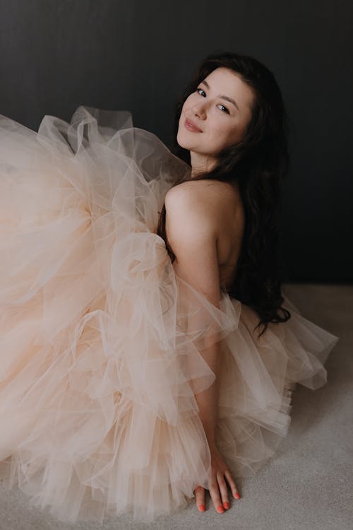 A woman in a nude colored tutu posing for a photo