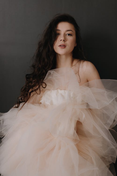 A woman in a nude colored tulle dress