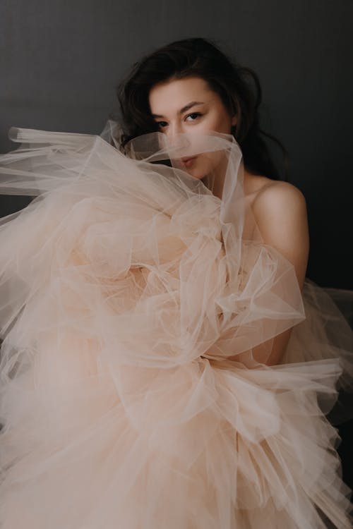 A woman in a nude colored tulle dress