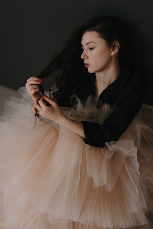 A woman is sitting on the floor with her hair in a tulle skirt