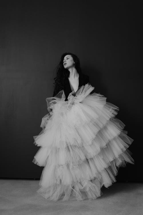 A woman in a tulle skirt posing for a black and white photo