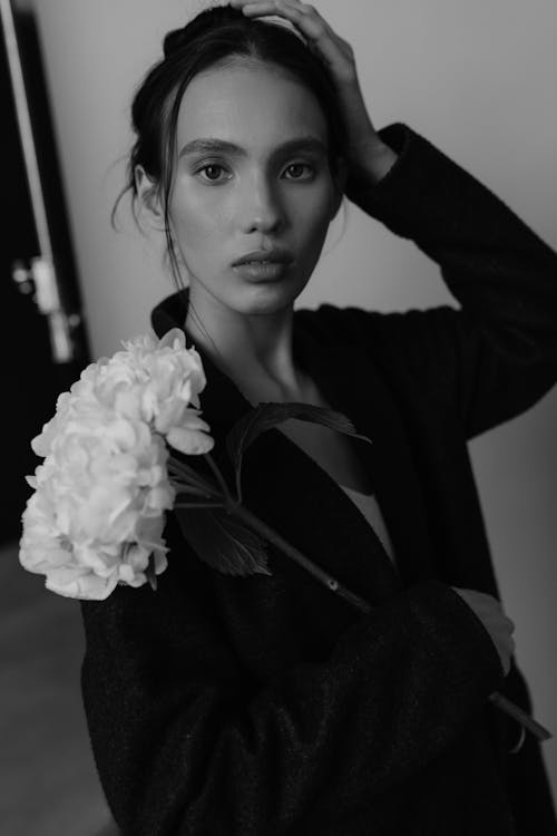 A woman in black and white holding a flower