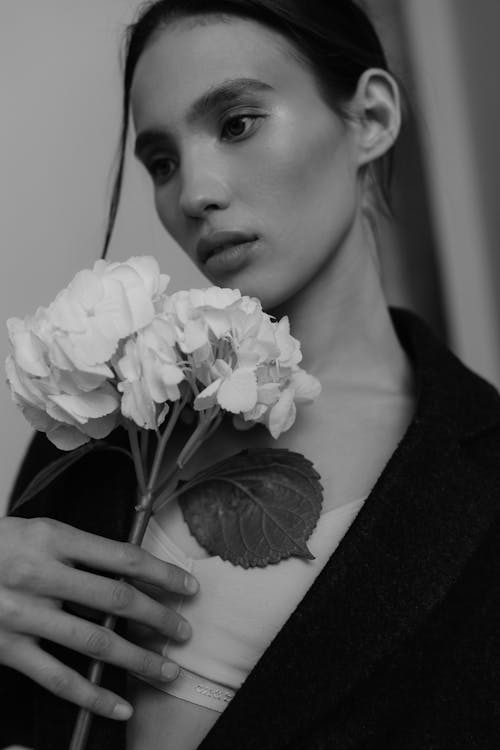 A woman in a jacket holding flowers