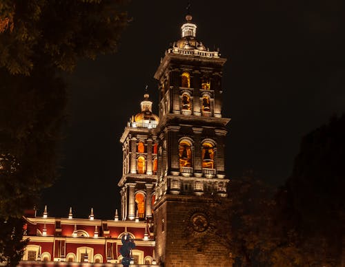 A church tower lit up at night with a clock