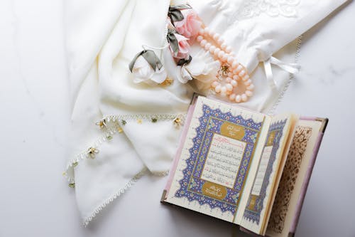 A book with a pearl necklace and a pearl ring