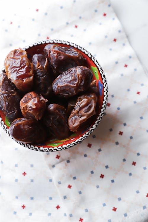 A bowl of dates on a tablecloth