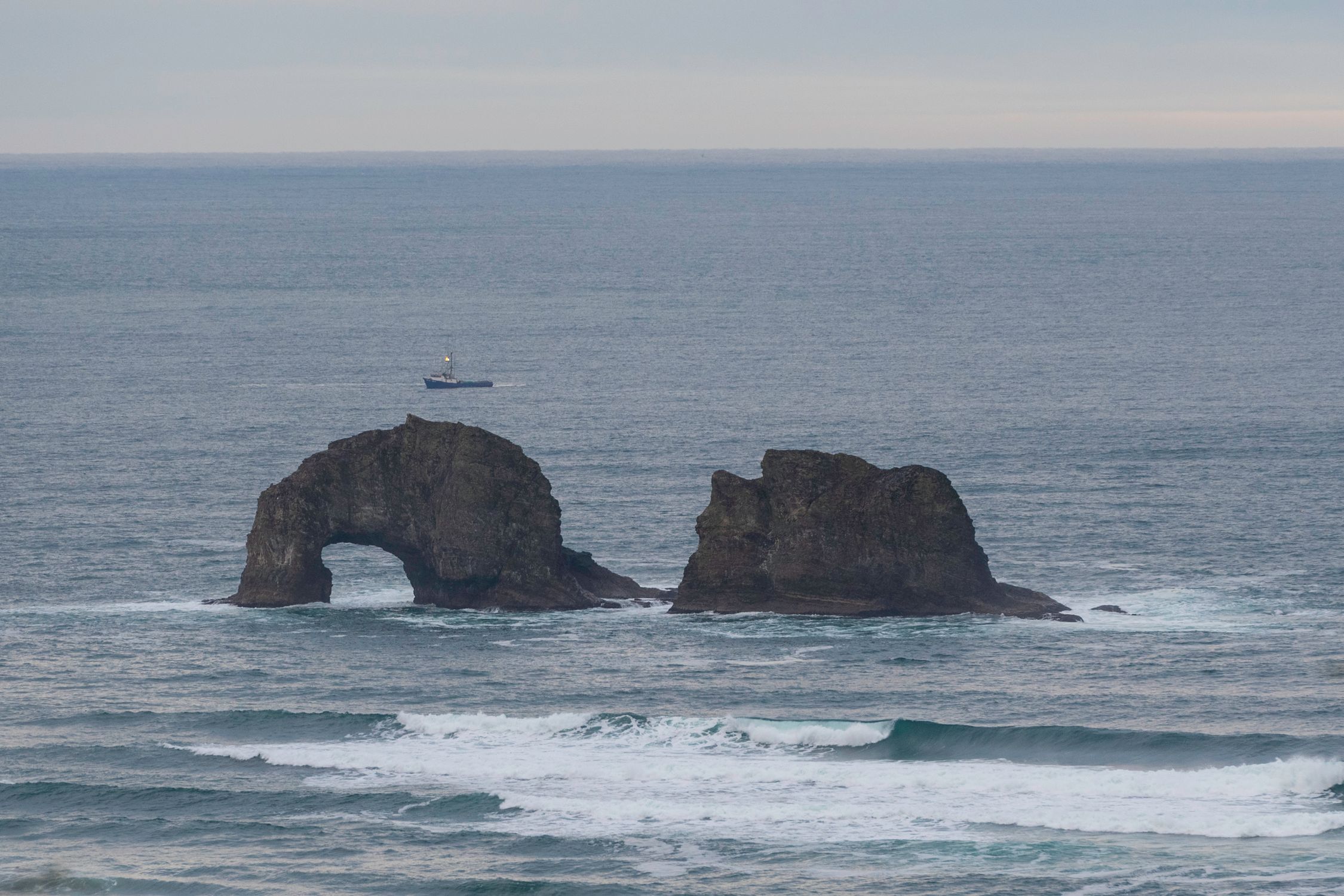 Discover the scenic rock arch formation at Rockaway Beach, Oregon, set against a serene ocean backdrop.
