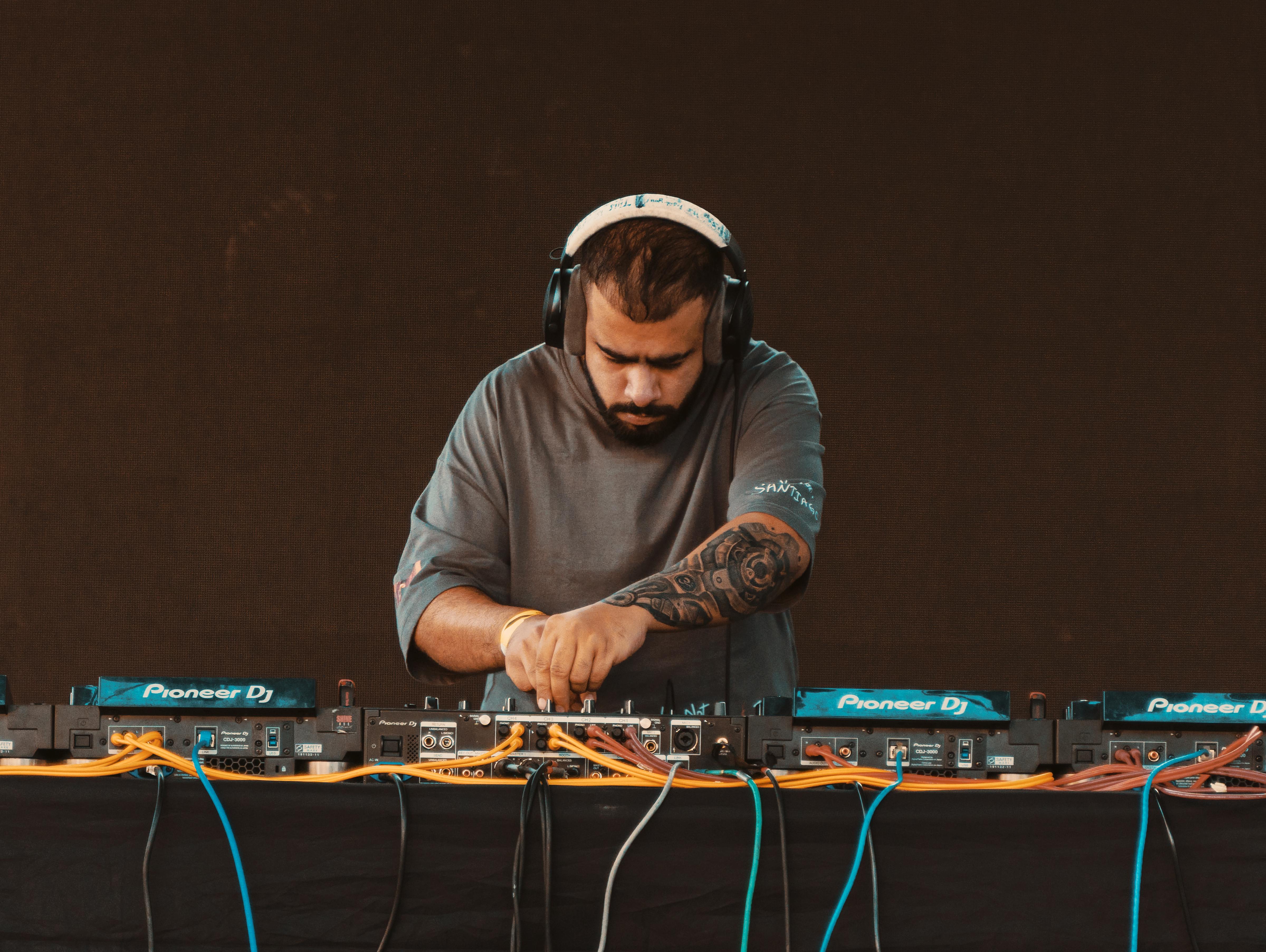 a dj with headphones and a beard playing music