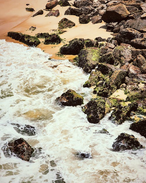 A photo of a rocky beach with waves crashing into the shore