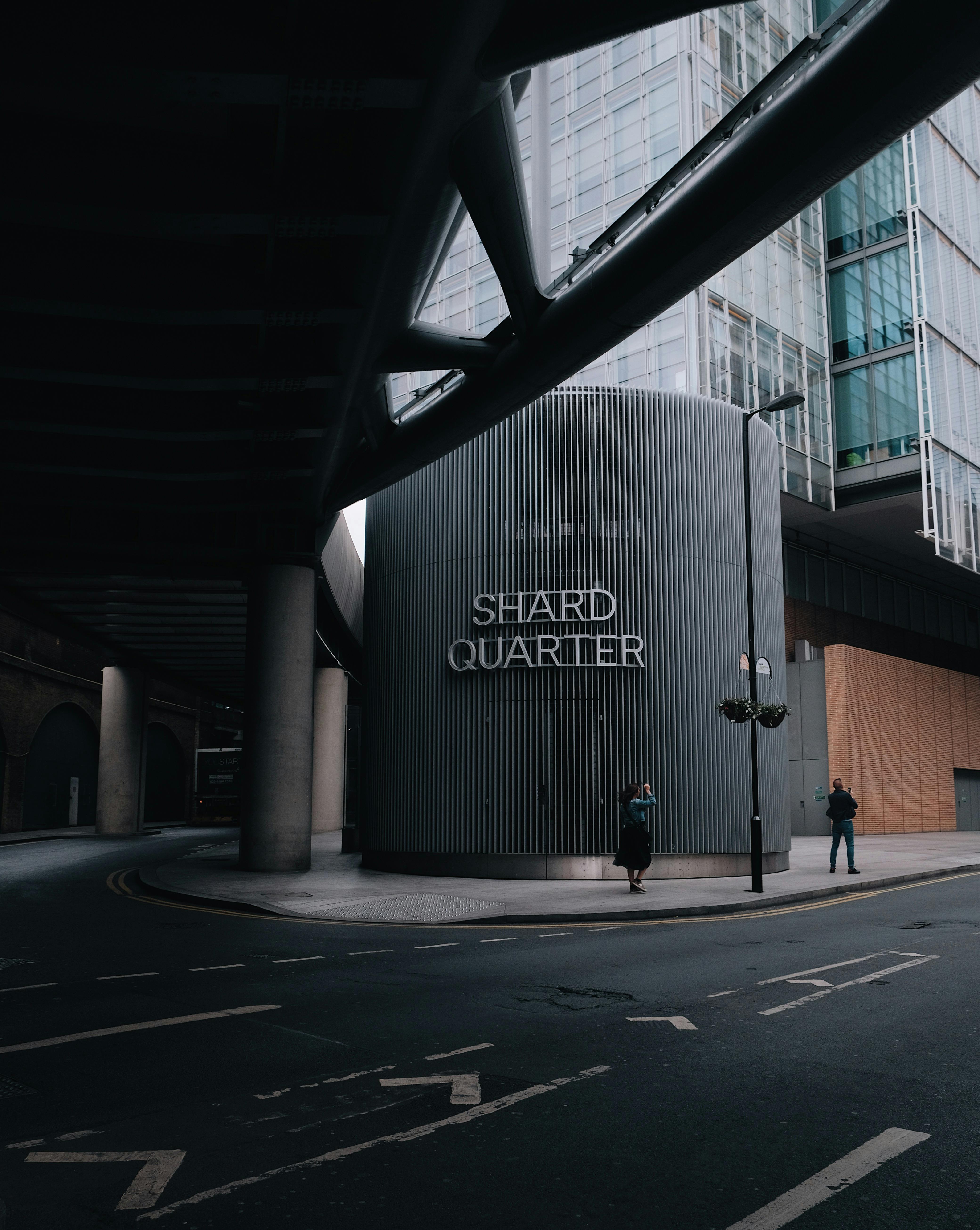 Moody urban shot of pedestrians near the iconic Shard Quarter in London.