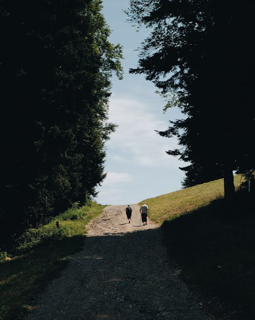 Woman and Man Hiking on Dirt Road