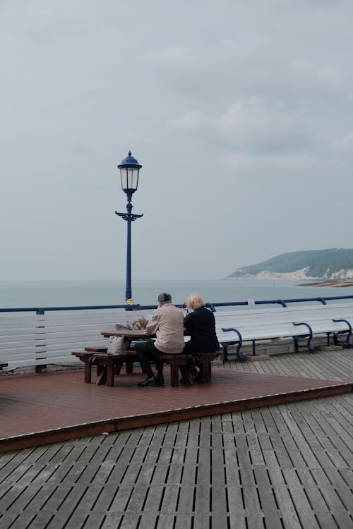 Elderly Men in Jackets Sitting on Pier