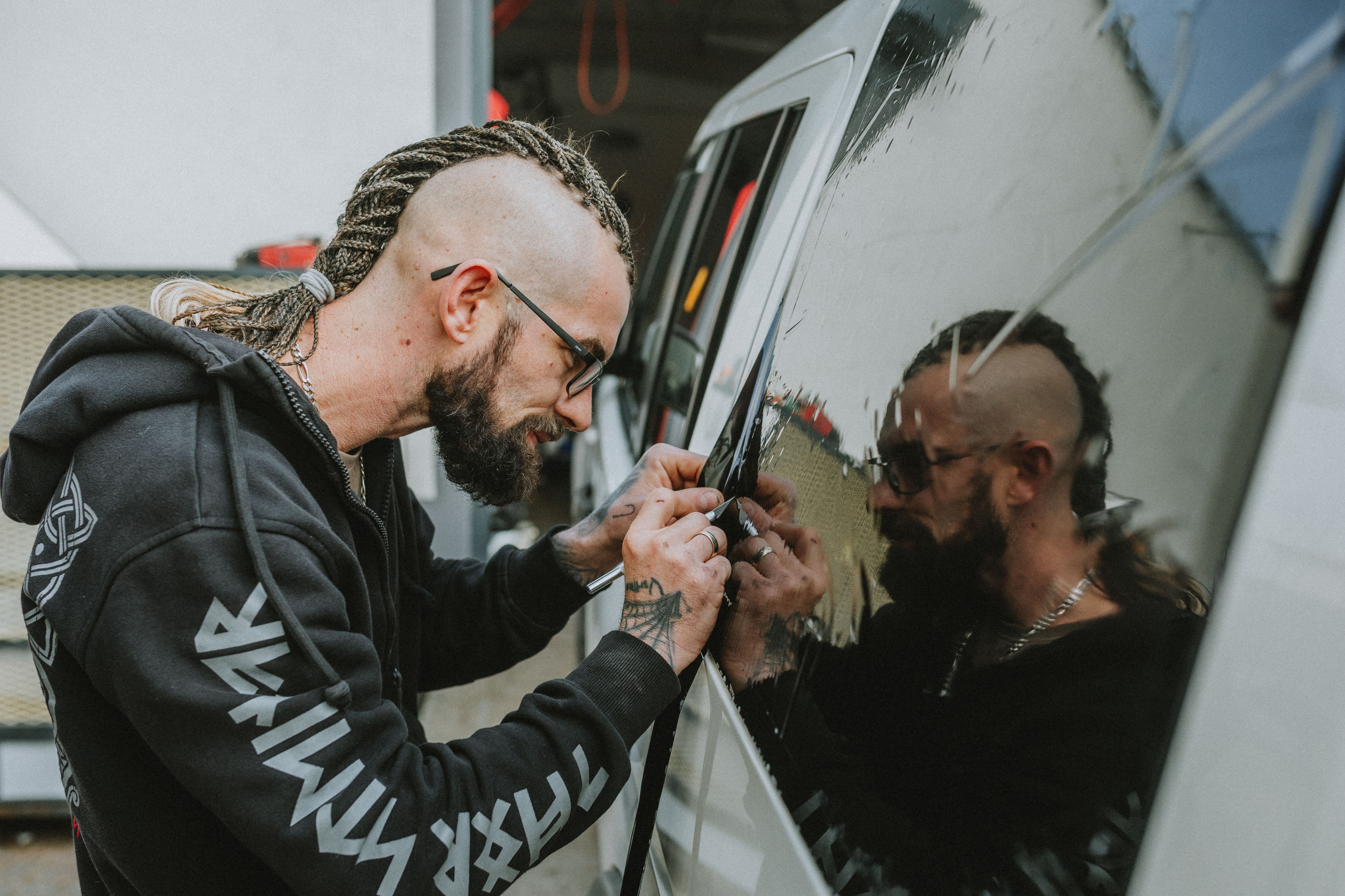 Installer working with window film on a vehicle — illustrative installation example