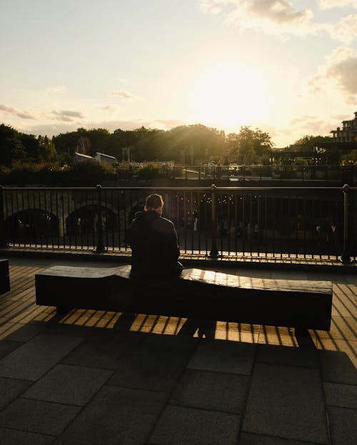 Man sitting on a bench in sunset
