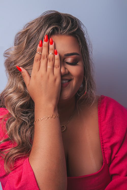 A woman with red nails covering her eyes