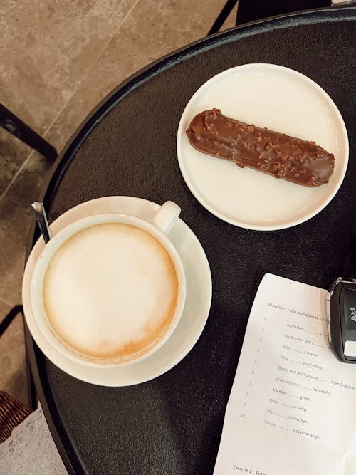 Cup of Cappuccino and Chocolate Sweet on Table