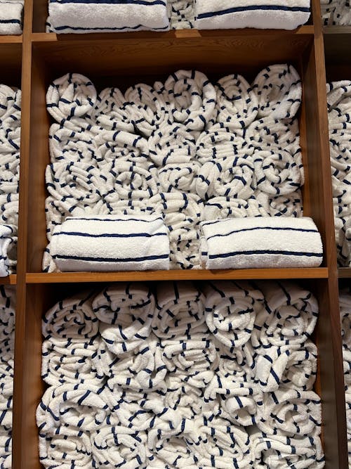 A shelf with towels and pillows on it