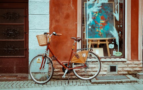 A red bicycle parked in front of a building