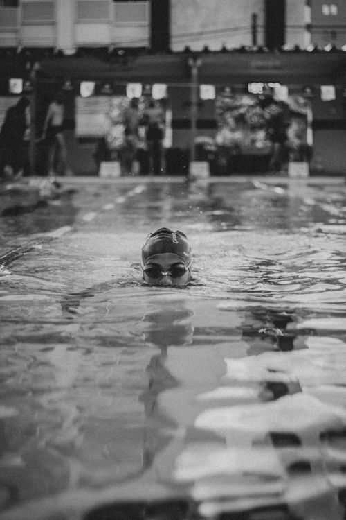 Free Dynamic black and white photo of a swimmer gliding through the pool surface. Stock Photo