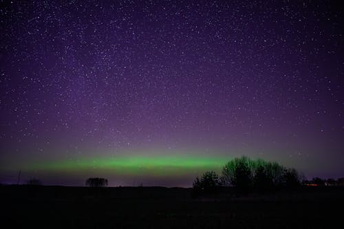 The aurora bore is seen in the sky over a field