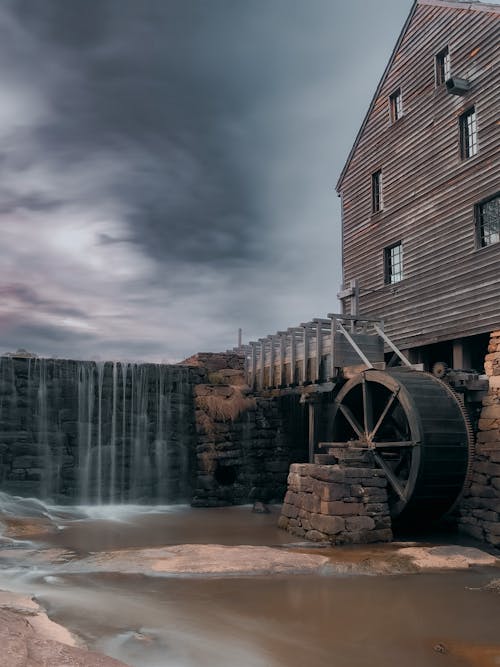 A water wheel is sitting in front of a building