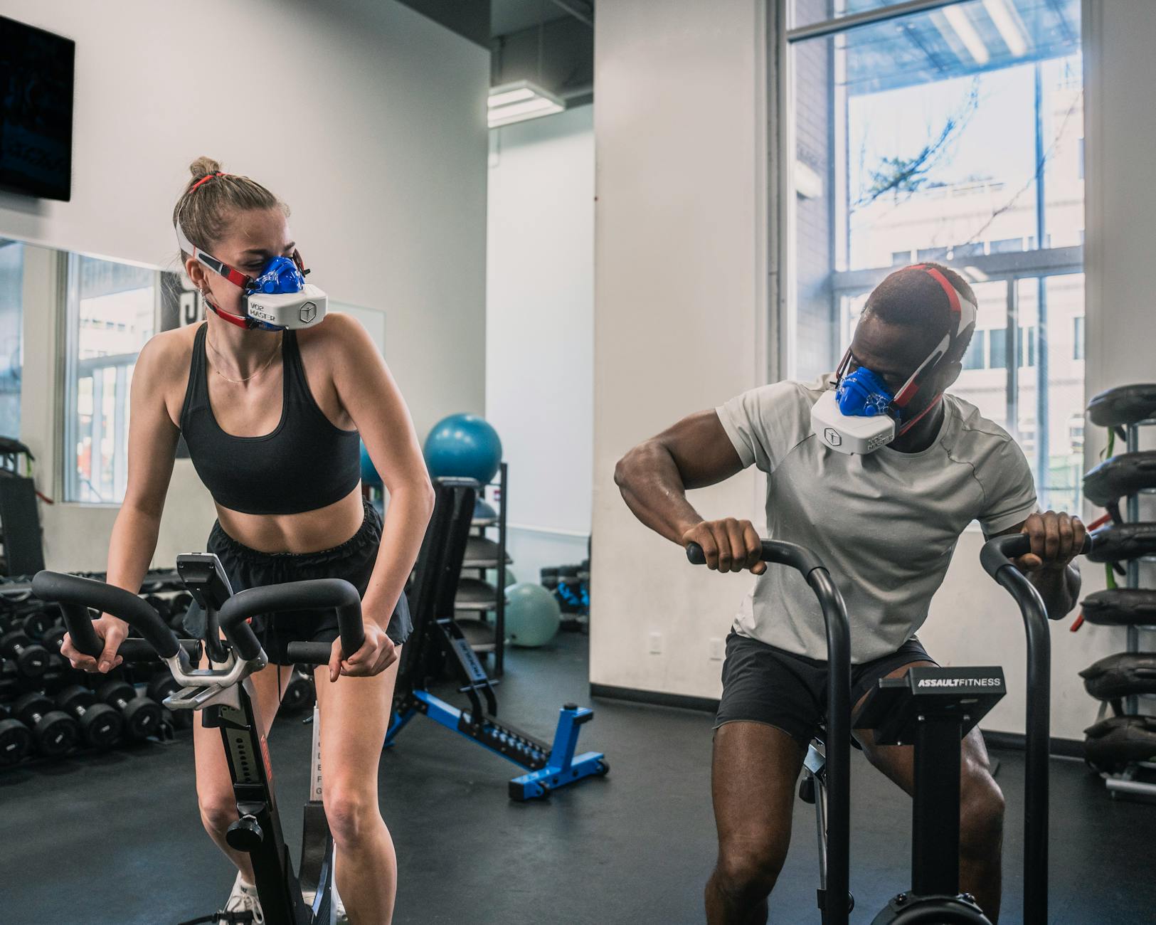 Athletes training indoors with specialized breathing masks for enhanced workout.