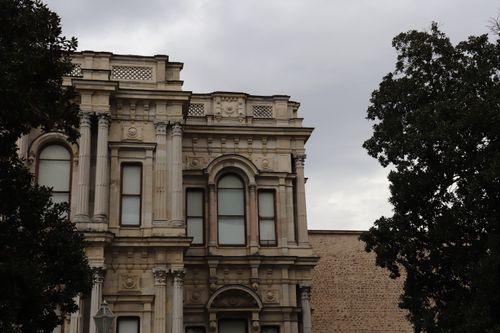 Free Detailed view of the Beylerbeyi Palace facade, Istanbul, surrounded by trees under an overcast sky. Stock Photo